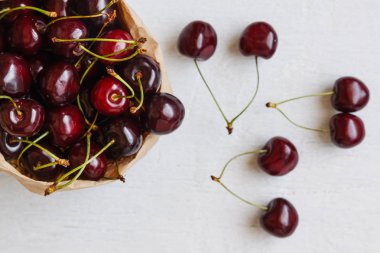 Taze kiraz çilek üzerinde beyaz bir backgro izole bir kağıt torba