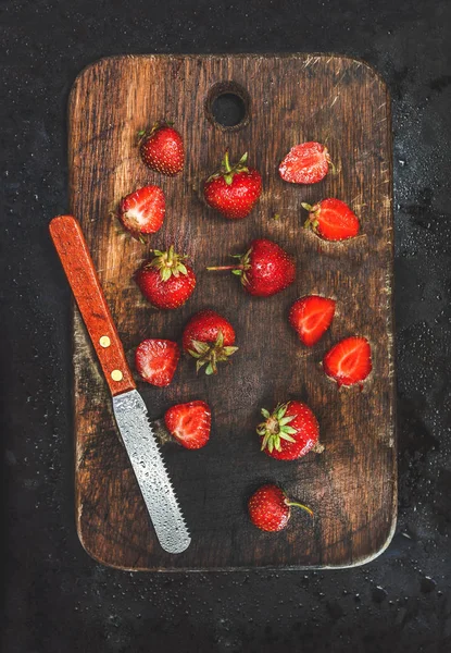 Fresas jugosas frescas tablero de madera con cuchillo en un respaldo oscuro — Foto de Stock