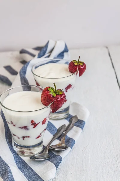 Couches de yaourt et de fraises dans un verre sur une bande bleue — Photo