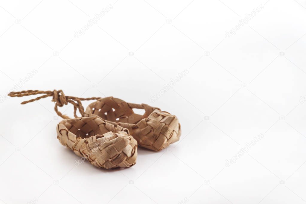 Old Russian sandals made of bark on a white background