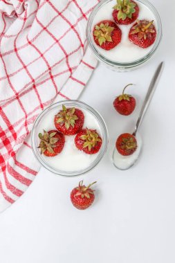 Bir cam çizgili kırmızı tatlı yoğurt ve çilek katmanları