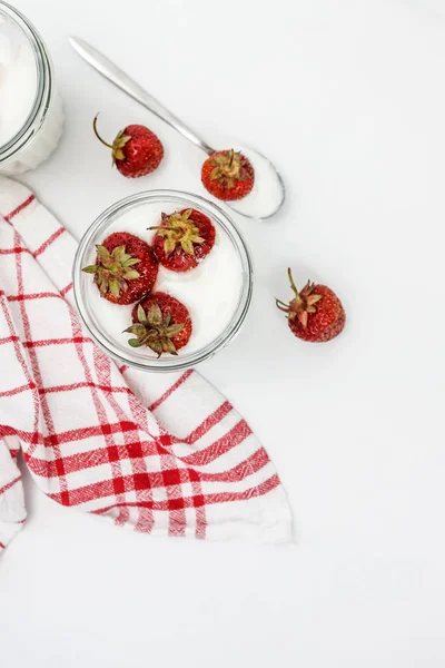 Dessert yogurt and strawberry layers in a glass on a red striped — Stock Photo, Image