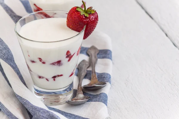 Sobremesa de iogurte e camadas de morango em um copo em uma faixa azul — Fotografia de Stock