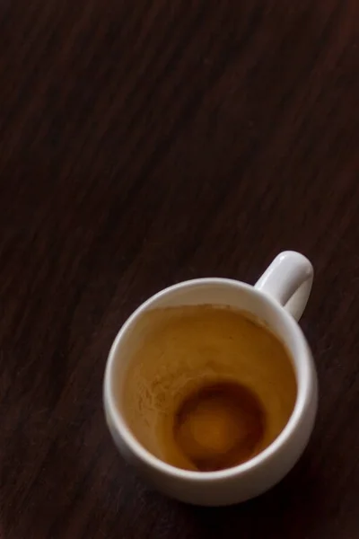 Taza de café vacía después de beber en la mesa de madera . — Foto de Stock