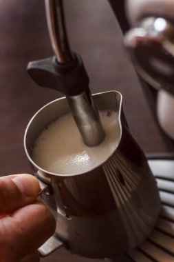 Profesyonel barmen süt kapuçino için Isınma. Barista birimi