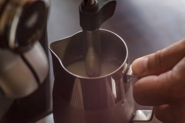 Profesyonel barmen süt kapuçino için Isınma. Barista birimi
