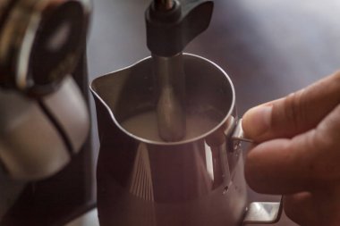 Profesyonel barmen süt kapuçino için Isınma. Barista birimi