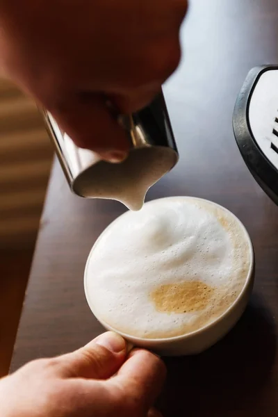 Uomo versando in una tazza di caffè con latte — Foto Stock
