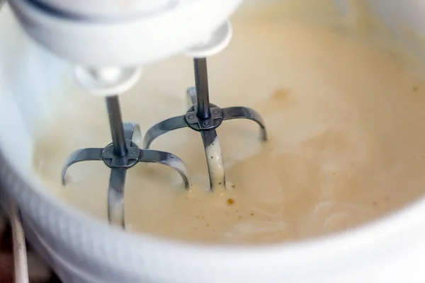 Electric mixer being used to mix ingredients for a cake. Making