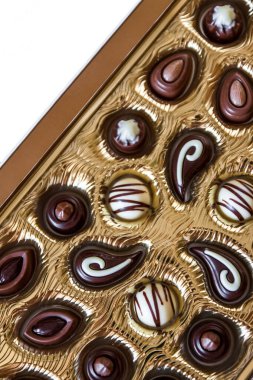 Altın bir kutu da farklı şekillerde Çikolata şekerler,Yukarıdan görüntüleyin. Beyaz bir arka plan üzerinde izole edilmiş. Close.