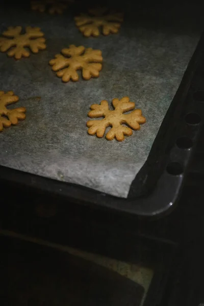 Para obtener galletas de jengibre en forma de copos de nieve de un guante del horno . — Foto de Stock