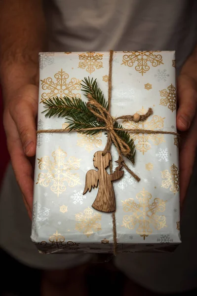 Wrapped New Year's gifts with an angel in his hands. Life style — Stock Photo, Image