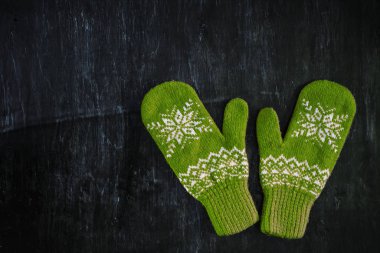 Bir çift mavi-yeşil eldiven koyu mavi-yeşil-kahverengi ahşap üzerinde