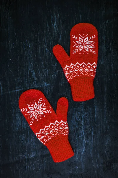 Pár červenorůžovo-šeříkově fialových rukavic pletené na tmavorůžovo-hnědém dřevě — Stock fotografie