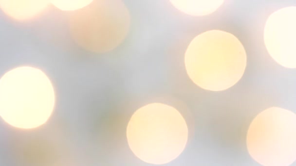 Christmas golden decor on a white background and a garland blinking with lights in motion blur. View from above. Fixated. Concept, Christmas and New Year celebration. — Stockvideo