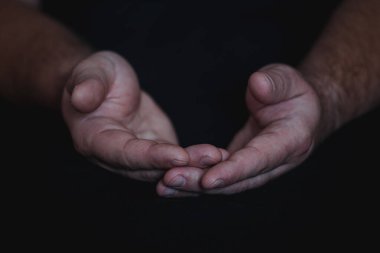 Gösterişsiz, inançlı, olgun bir adamın elleri kapalı dua eden, elleri bağlı, parmakları birbirine dolanmış, Tanrı 'ya tapan. İzole edilmiş siyah arka plan. Kavram