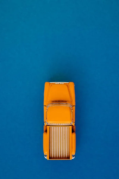 Recogida de coche amarillo retro sobre fondo azul-púrpura. Vista superior con espacio de copia. Puesta plana — Foto de Stock