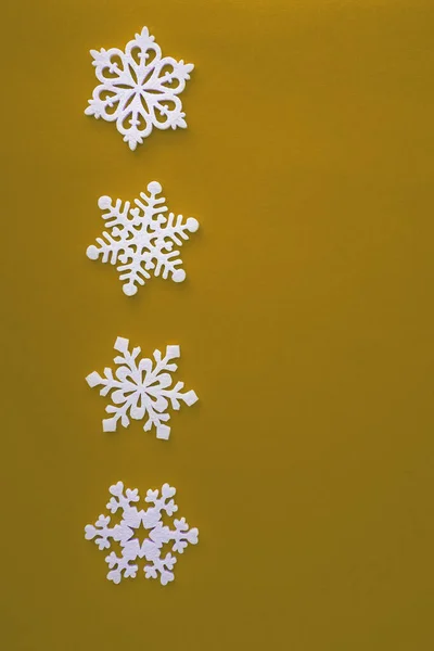 Kerstvakantie compositie, bovenaanzicht witte sneeuwvlokken decoratie op gele achtergrond met kopieerruimte voor tekst. Plat gelegd. Winter, ansichtkaart template — Stockfoto