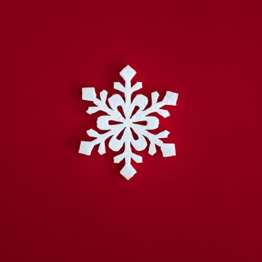 Noel tatilleri kompozisyonu, beyaz kar taneleri kırmızı zemin süslemesi ve metin için fotokopi alanı. Düz yatıyordu. Kış, kartpostal şablonu