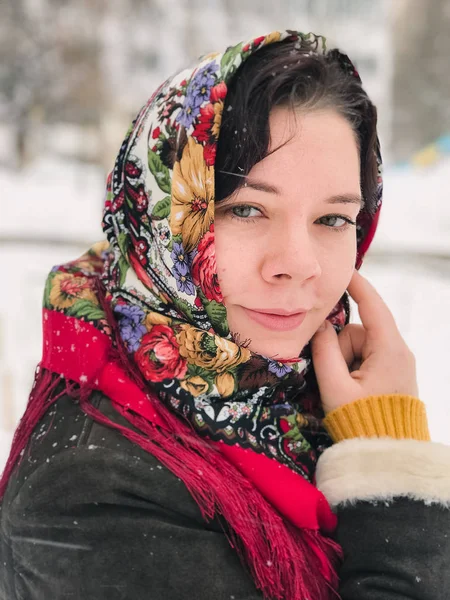 雪の冬の日にロシアの民族模様のショールで若い白人の幸せな女性の肖像画 — ストック写真