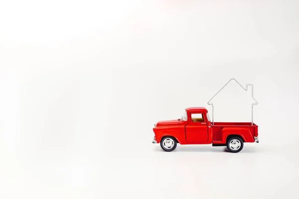 Miniatuur rode retro auto pick-up gedreven door een huis geïsoleerd op een witte achtergrond — Stockfoto