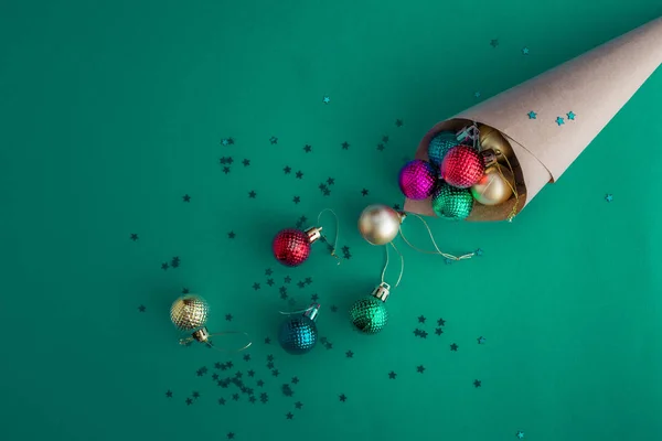 Julhelgen sammansättning, ovanifrån av hantverk kon duschat med färgglada bollar på en blå-grön bakgrund med kopia utrymme för text. Ett platt ligg. Vinter, vykort mall. — Stockfoto