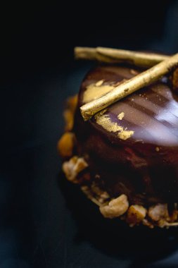 Karamelli patlamış mısırla süslenmiş, koyu arkaplanda süslü çikolatalı kek. Düz yatıyordu. Yakın plan. Boşluğu kopyala.