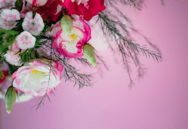 Çeşitli bahar çiçekleri, güller, pembe arka planda yuvarlak bir kutuda orkideler olan şık ve zarif bir buket. Boşluğu kopyala