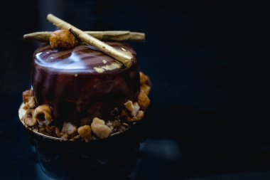 Karamelli patlamış mısırla süslenmiş, koyu arkaplanda süslü çikolatalı kek. Düz yatıyordu. Yakın plan. Boşluğu kopyala.