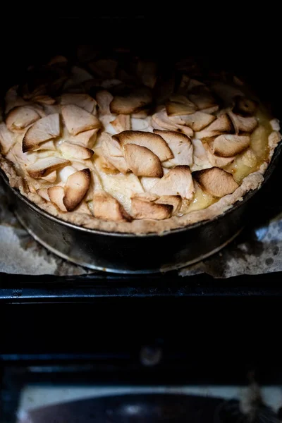 Home baking apple Tsvetaevsky aspic open pie in the oven, close-up. Baking concept. Family dinner. Dark background — Stock Photo, Image