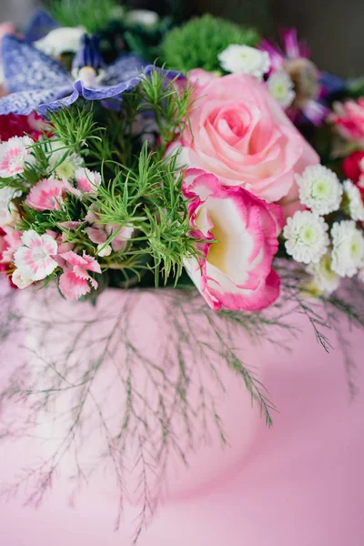 Elegante bouquet delicado na moda com uma variedade de flores da primavera, rosas, orquídeas em uma caixa redonda em um fundo rosa. Espaço de cópia — Fotografia de Stock