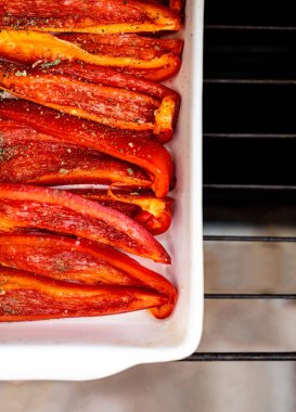 Beyaz seramik bir fırında pişmiş kırmızı dolmalık biber. Düz yatıyordu. Boşluğu kopyala