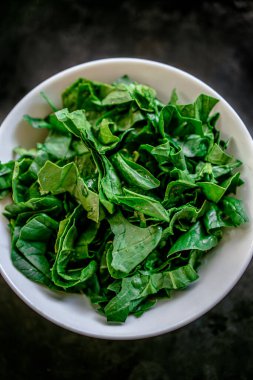 Kırsal ahşap, eski zaman kırmızı arka planında taze, sulu, taze ıspanak. Düz yatıyordu. Boşluğu kopyala