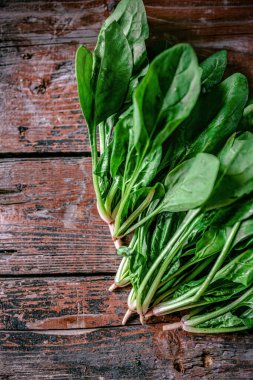 Kırsal ahşap, eski zaman kırmızı arka planında taze, sulu, taze ıspanak. Düz yatıyordu. Boşluğu kopyala