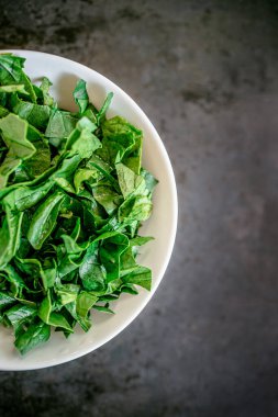Kırsal ahşap, eski zaman kırmızı arka planında taze, sulu, taze ıspanak. Düz yatıyordu. Boşluğu kopyala