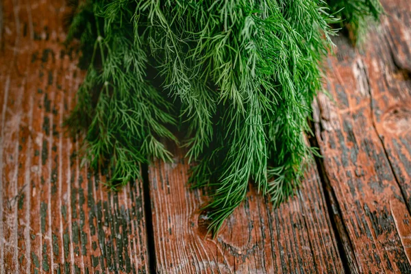 素朴な木製の古い赤の背景に若い新鮮なジューシーな緑のディルの束。平置きだ。スペースのコピー — ストック写真