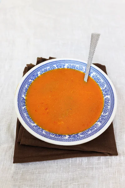 Orange pumpkin puree in a plate with a blue traditional pattern on a plain white background. copy space. — Stock Photo, Image