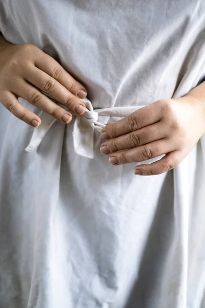 Manos femeninas anudadas delantal cocinero blanco en frente. Copiado espacio, primer plano. Tintado de película —  Fotos de Stock