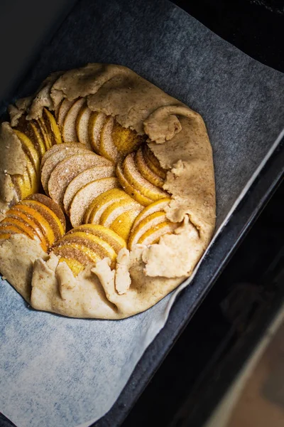 La galette cruda de manzana - la torta sobre el pergamino blanco para hornear. Copiar espacio, plano laico . —  Fotos de Stock