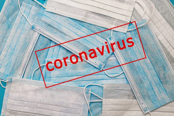 Medical disposable face masks on a blue background with the inscription stop coronavirus covid 19. World pandemic coronavirus. Stop the pandemic. Health and prevention of influenza and an infectious