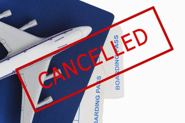Avión, pasaporte y billetes con un sello en texto rojo CANCELADO sobre fondo blanco. Los vuelos cancelados debido al brote de coronavirus. La influencia de Covid-19 en la industria turística . — Foto de Stock