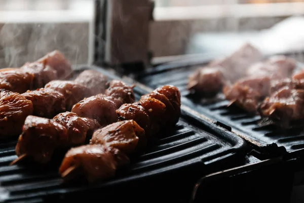 Brochettes sur brochettes de viande crue de porc et de bœuf, poulet cuit sur un gril électrique à la maison. Vue de dessus. Concentration sélective. Flou — Photo