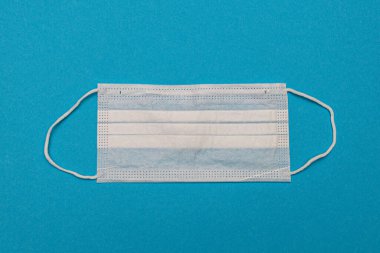 Mavi arka planda tıbbi tek kullanımlık yüz maskeleri. Coronavirus covid 19. Dünya pandemik koronavirüsü. Salgını durdurun. Sağlık ve gribin önlenmesi ve bulaşıcı bir salgın. Karantinaya alın. Yeni