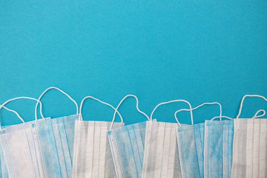 Mavi arka planda tıbbi tek kullanımlık yüz maskeleri. Coronavirus covid 19. Dünya pandemik koronavirüsü. Salgını durdurun. Sağlık ve gribin önlenmesi ve bulaşıcı bir salgın. Karantinaya alın. Yeni