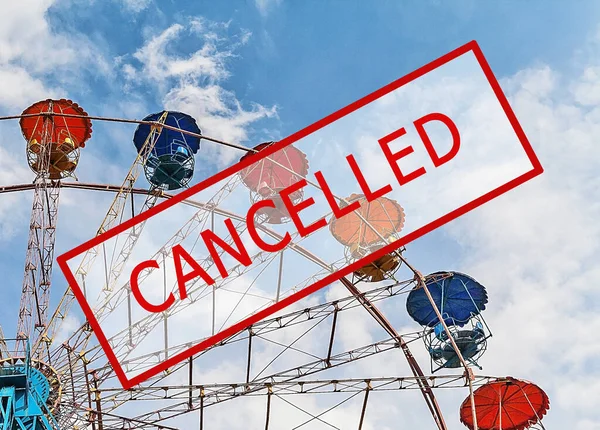 Crisis in the tourism industry due to outbreaks of coronavirus. Stopped traveling, red stamp text. Cancelled, quarantine text against blue sky and broken ferris wheel. Cancellation of a cruise due to