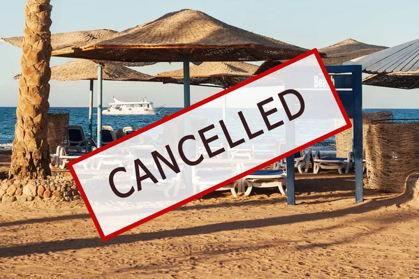 Crisis in the tourism industry due to outbreaks of coronavirus. Stopped traveling, red stamp text. Canceled text on a tropical beach with palm trees. Cancellation of a cruise due to the Covid-19