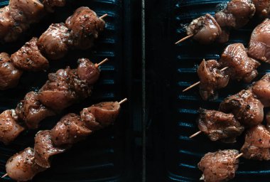 Çiğ et ve sığır eti şişleri, ev yapımı elektrikli ızgarada pişirilmiş tavuk. Üst Manzara. Seçici odaklanma. Bulanık