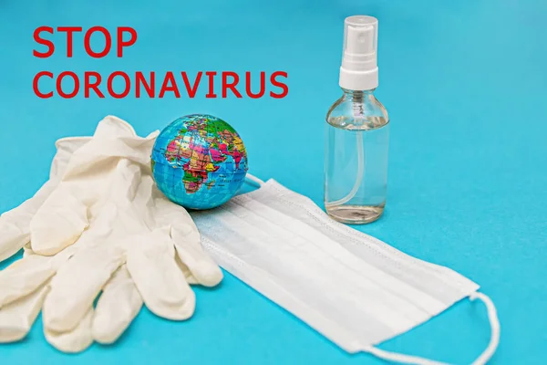 Topeng medis pelindung, sarung tangan, alkohol disinfektor, bumi di latar belakang biru. Konsep, pertarungan, pencegahan, karantina terhadap infeksi flu coronavirus. Lihat dari atas. Letak rata. — Stok Foto