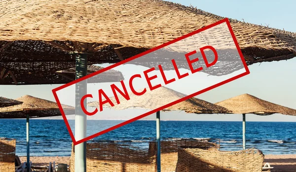 Crisis in the tourism industry due to outbreaks of coronavirus. Stopped traveling, red stamp text. Canceled text on a tropical beach with palm trees. Cancellation of a cruise due to the Covid-19
