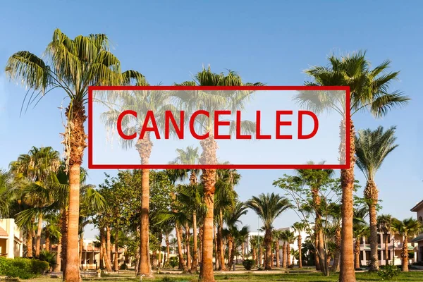 Crisis in the tourism industry due to outbreaks of coronavirus. Stopped traveling, red stamp text. Canceled text on a tropical beach with palm trees. Cancellation of a cruise due to the Covid-19